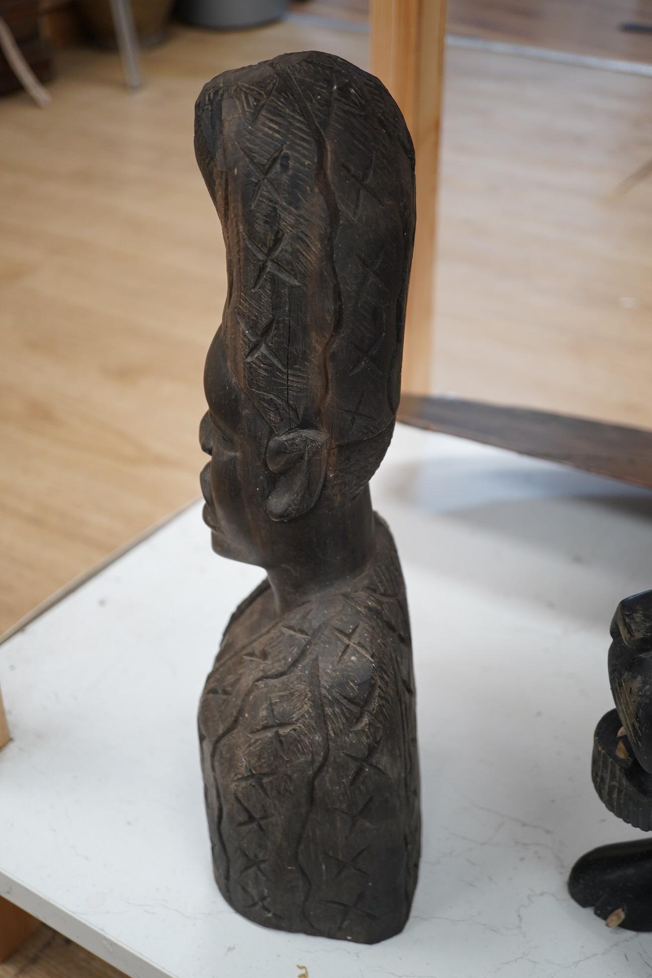 An African hardwood carving of a bust, 41cm high and an ebony Indian carving of a lion, 35cm long, (2). Condition - fair